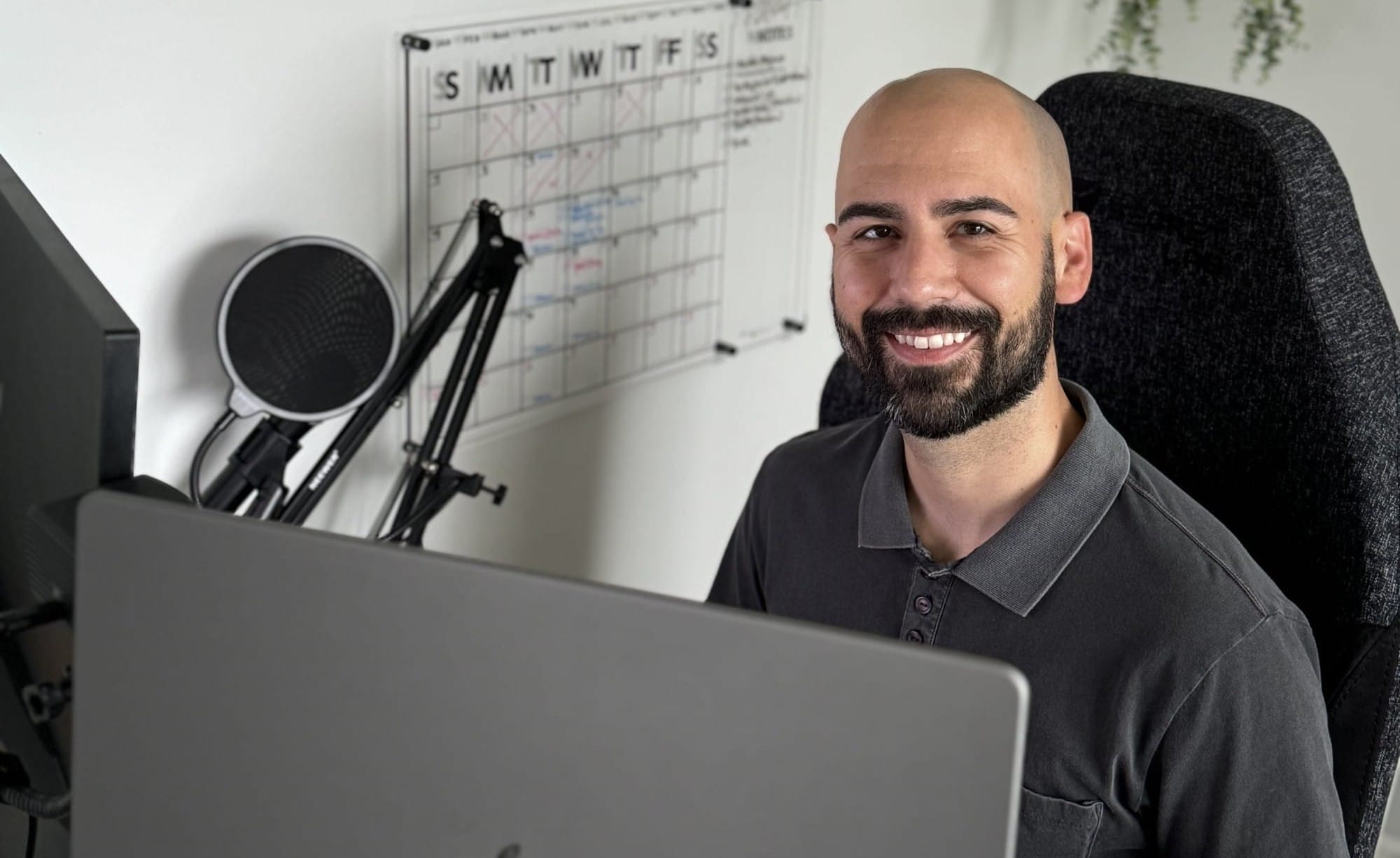 Adam smiling behind the computer